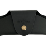 Small Soft Leather Eye Glasses Case in Black, closed, front view with embossed Hedonist logo and snap closure