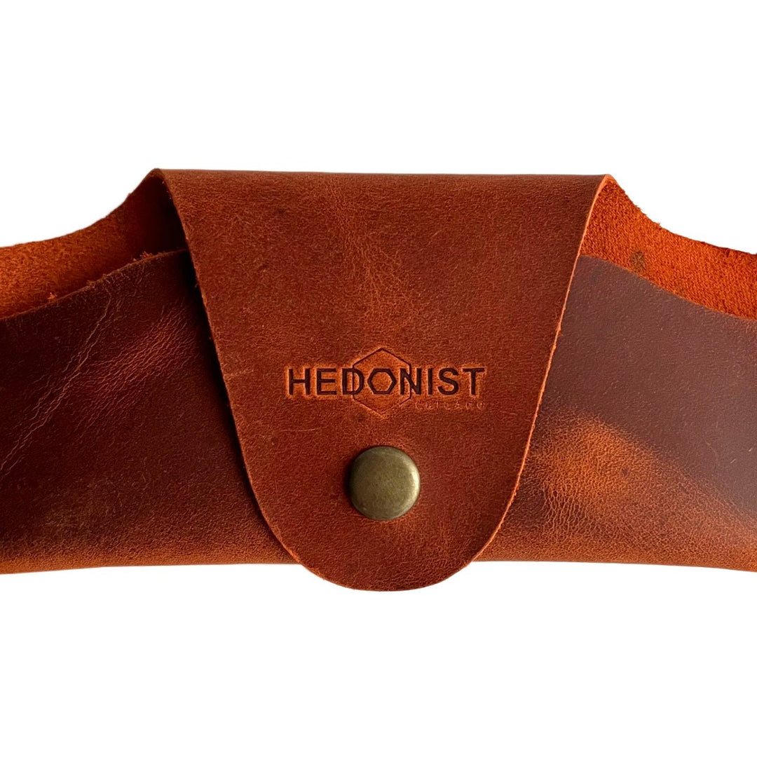 Small Soft Leather Eye Glasses Case in Cognac, closed, front view with embossed Hedonist logo and snap closure