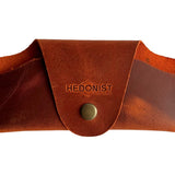 Small Soft Leather Eye Glasses Case in Cognac, closed, front view with embossed Hedonist logo and snap closure