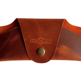 Small Soft Leather Eye Glasses Case in Cognac, closed, front view with embossed Hedonist logo and snap closure