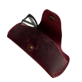 Small Soft Leather Eye Glasses Case in Burgundy, angled view with black-framed eyeglasses tucked inside
