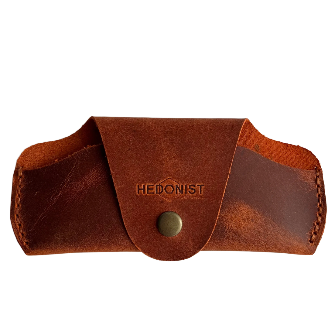 Small Soft Leather Eye Glasses Case in Cognac, closed, front view with embossed Hedonist logo and snap closure