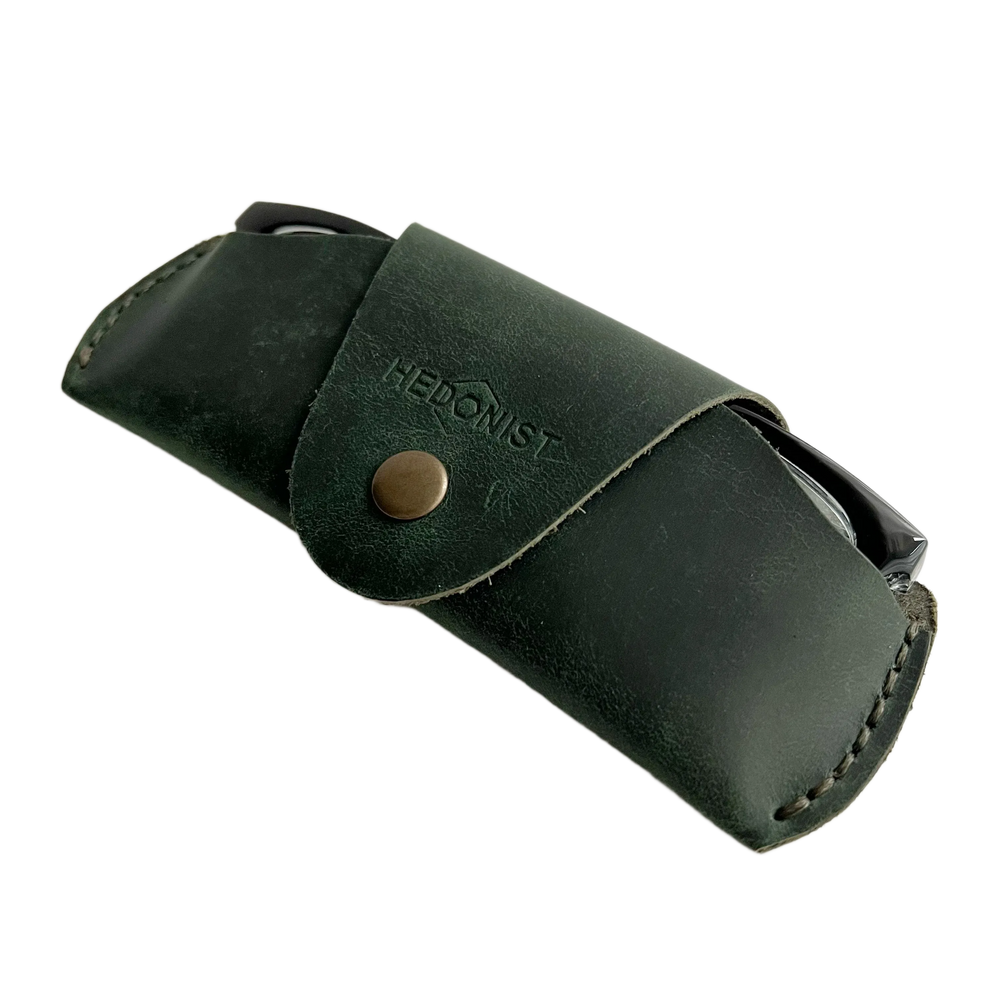 Small Soft Leather Eye Glasses Case in Dark Green, angled view with black-framed eyeglasses tucked inside