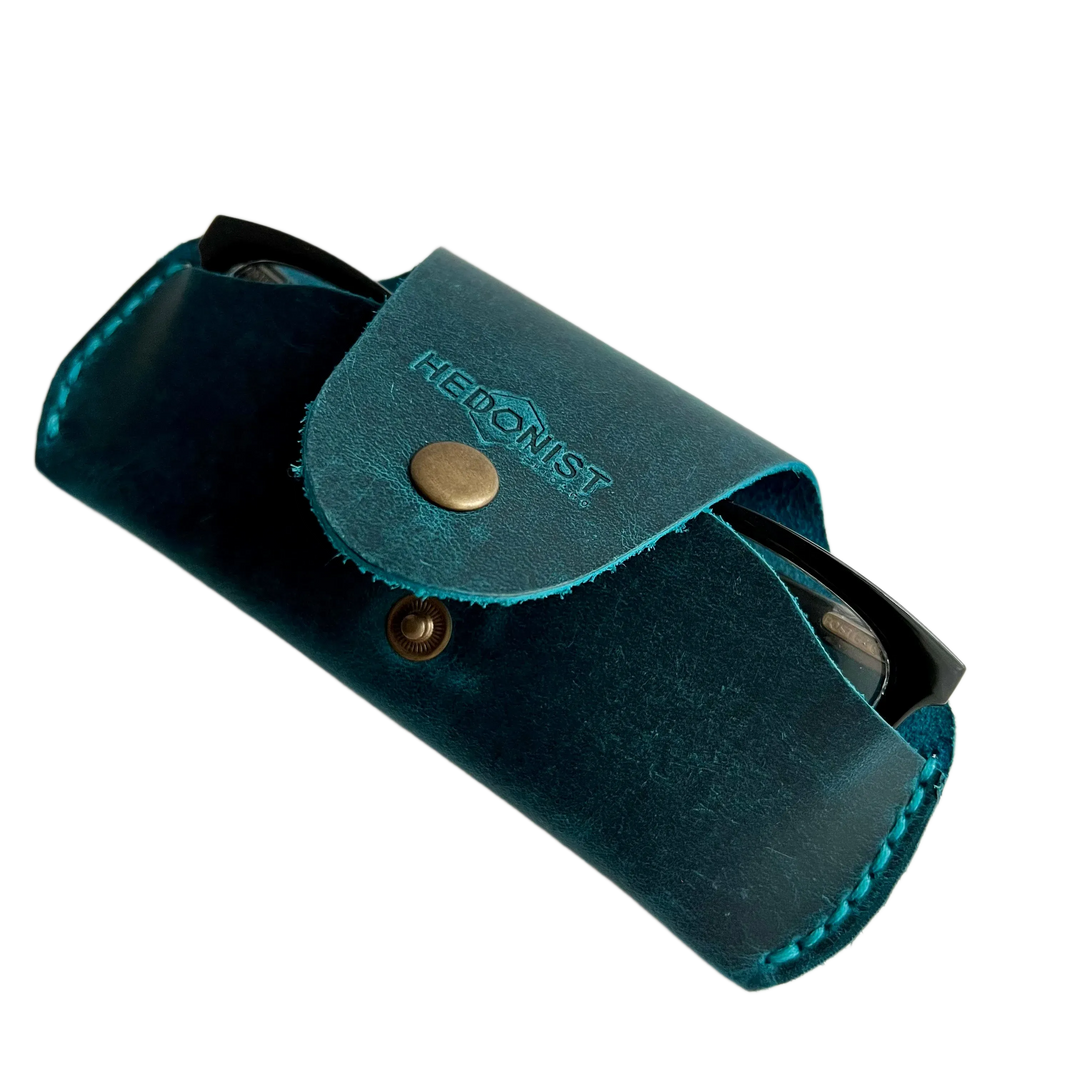 Small Soft Leather Eye Glasses Case in Teal, angled view with black-framed eyeglasses tucked inside
