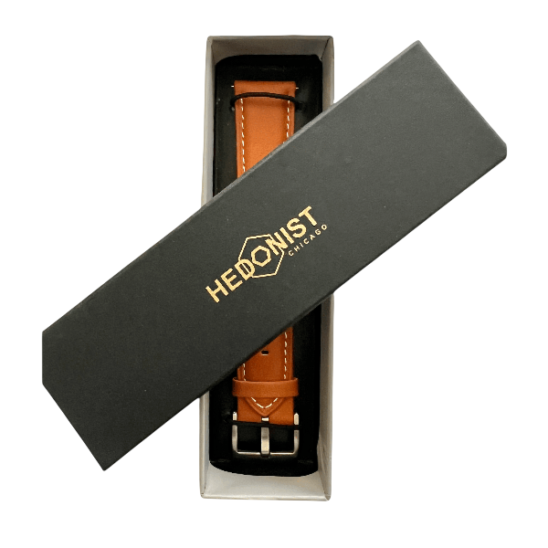 Tan leather watch band, close-up of logo detail