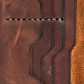 Handmade light mahogany pull-up leather card holder, close-up of leather texture and stitching