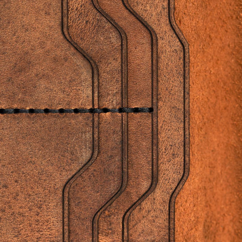 Handmade tan pull-up leather card holder, close-up of leather texture and stitching